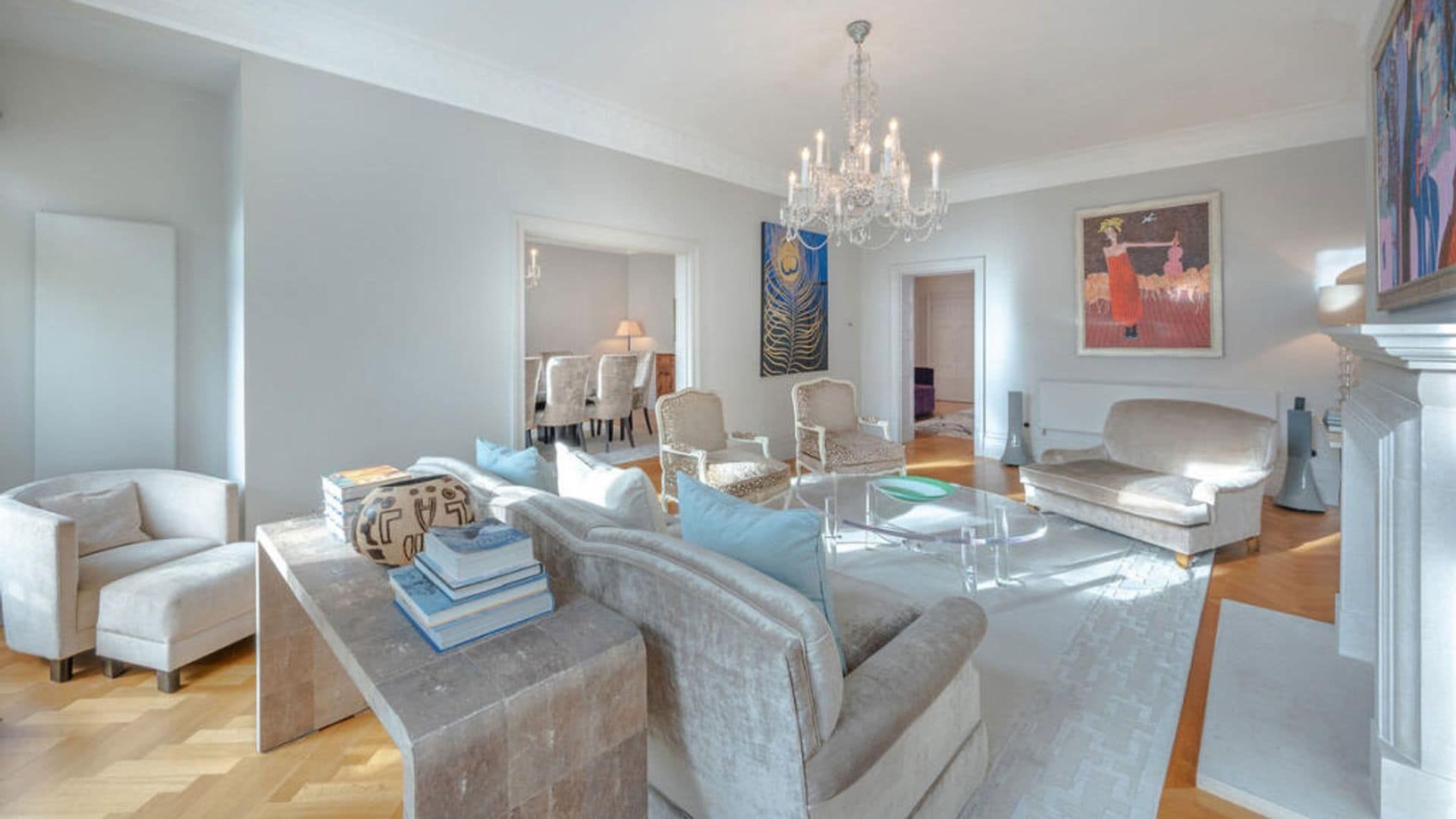 Chimney living room, spider lamp, carpet, sofas and beige velvet seats, transparent center table