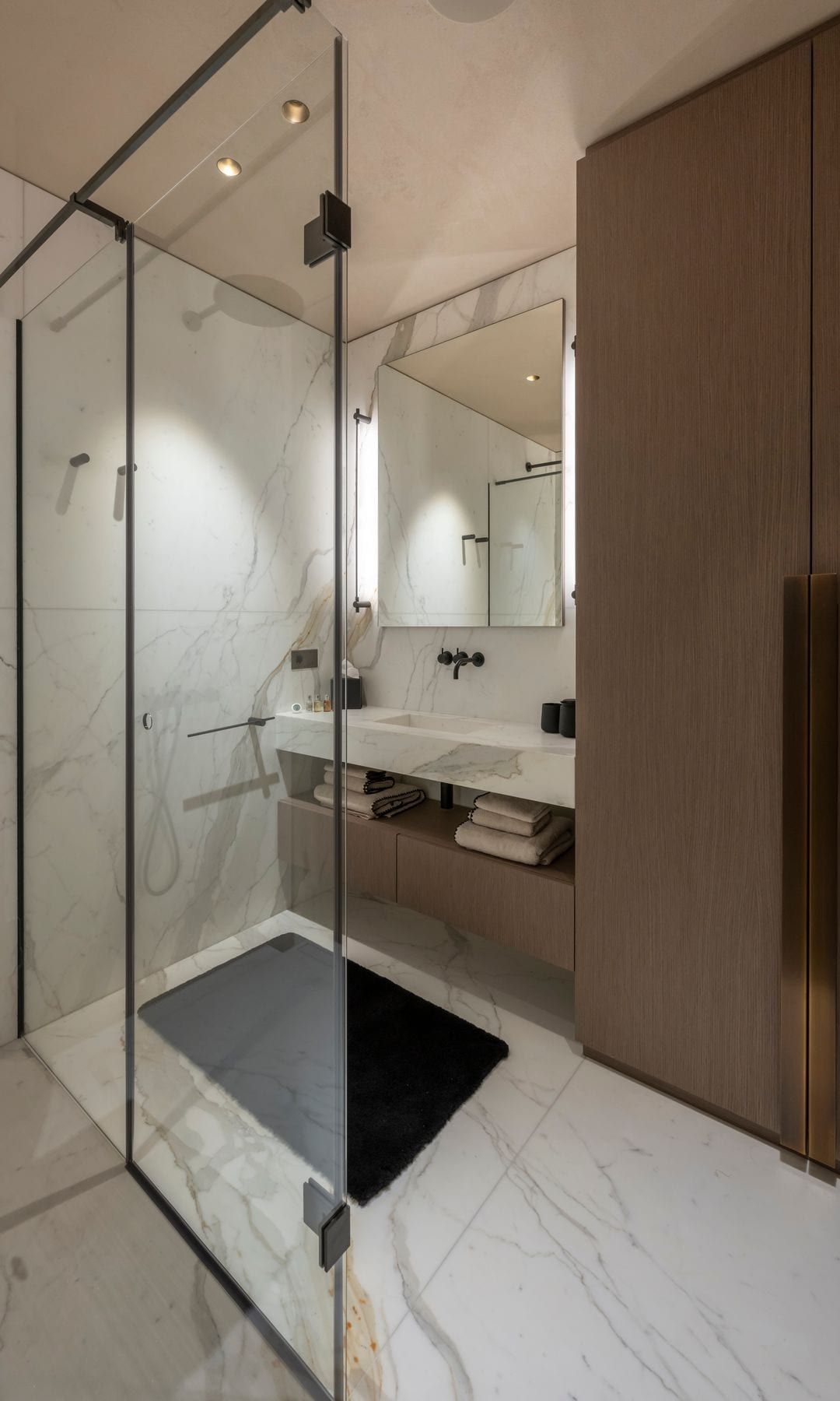 Bathroom with soil and marble walls, shower screen, wooden closet, mirror