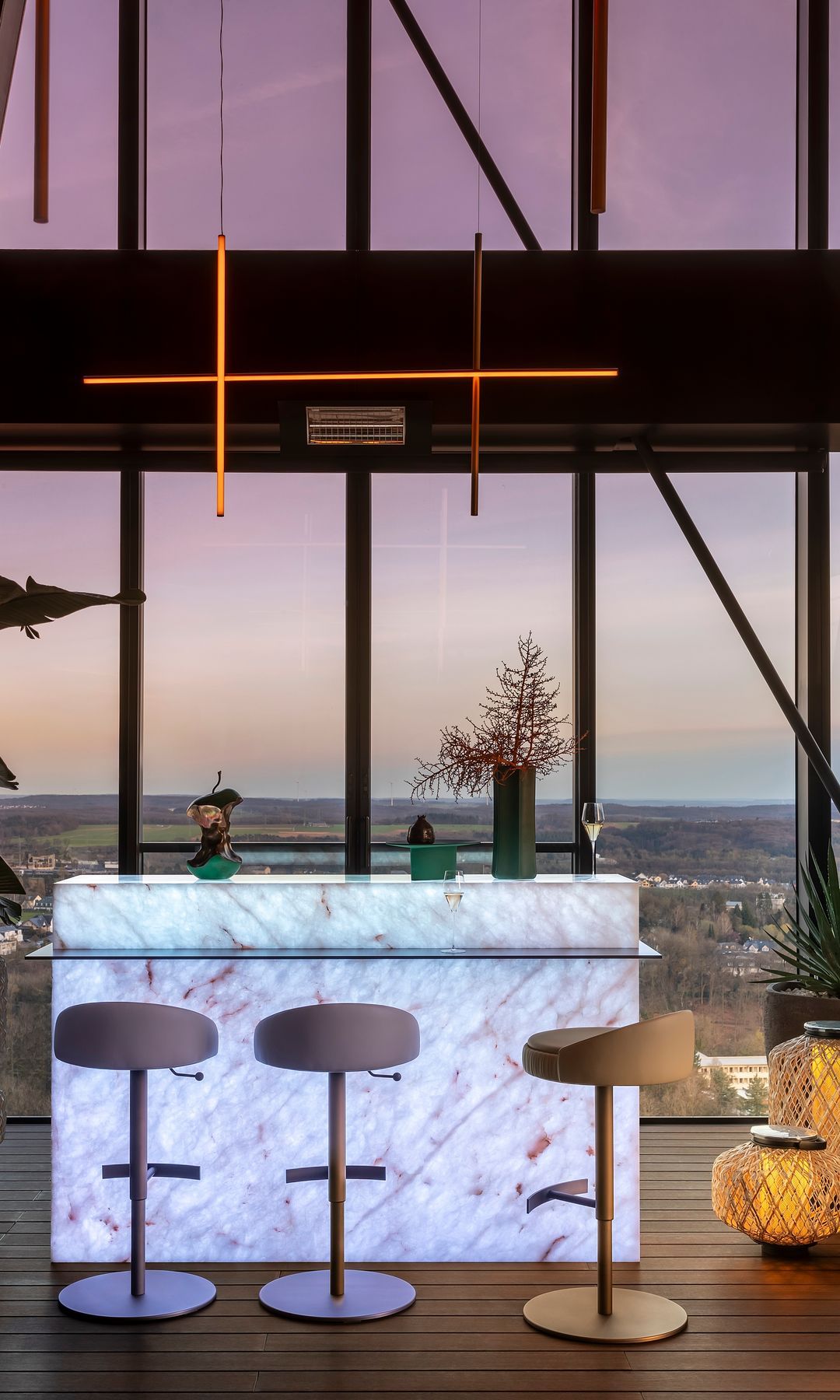 Living room with large windows, retroiluminated bar bar, stools and ceiling lamp