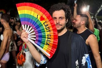 A young man holds a fan