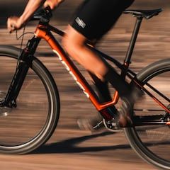 Cyclist pedaling along a path with the new orbea bicycle soul 2025.