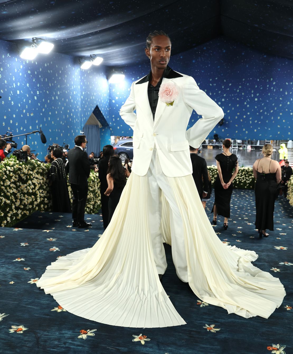 Model Christian Latchman, the face of this year’s catalog cover, arrived at the Met Gala in a whimsical cream-colored suit and pleated train.