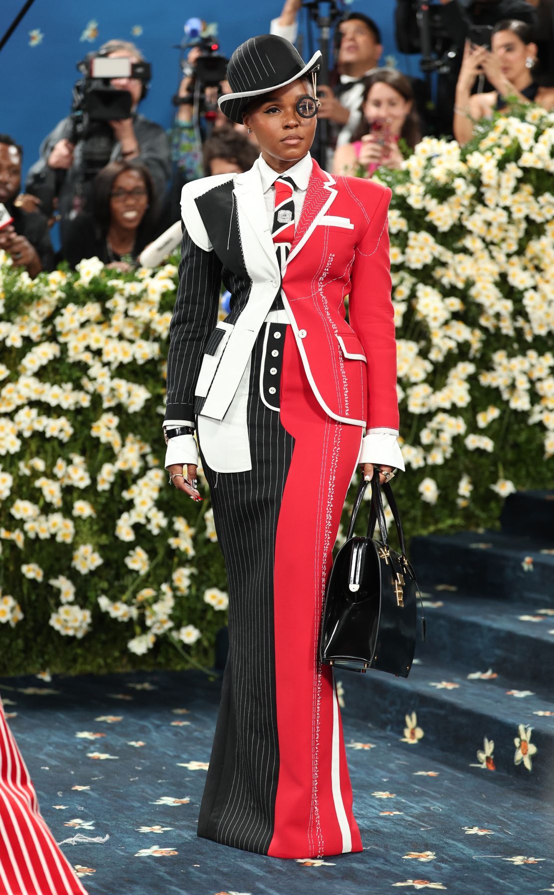 The singer and actor then removed the jacket to reveal a time-traveler-inspired black-and-red Thom Browne outfit.
