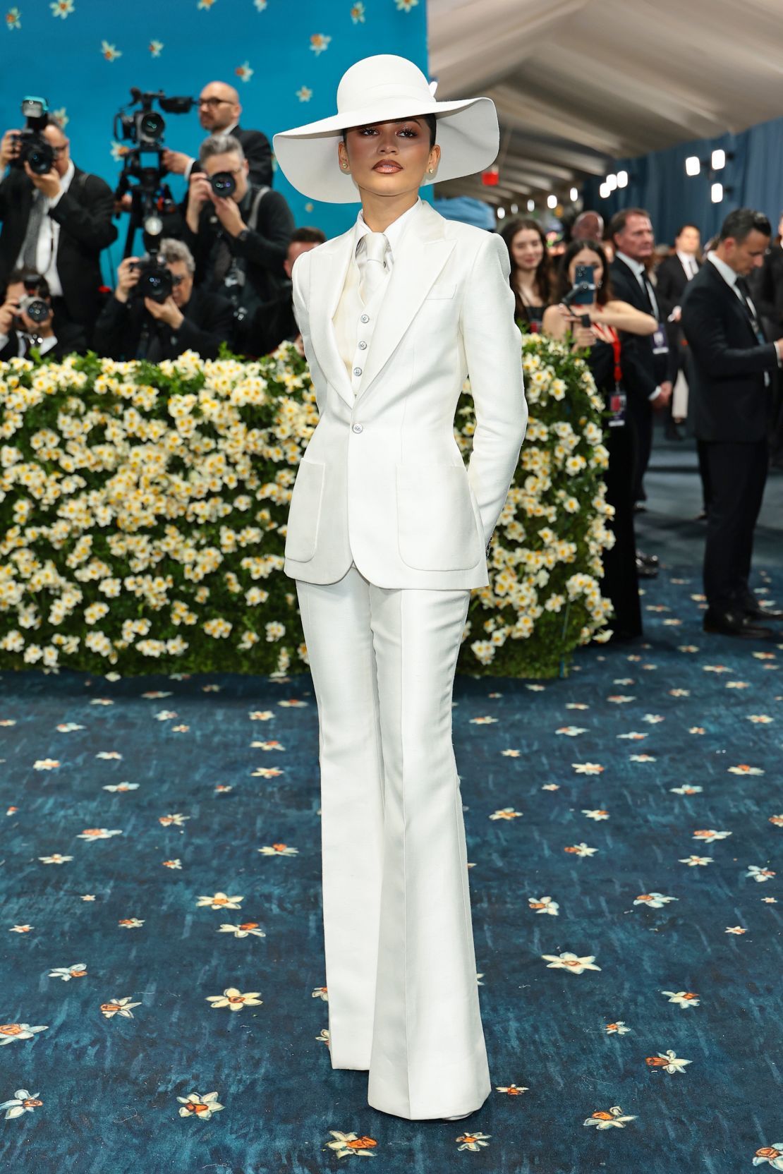 Channeling ‘70s Bianca Jagger, Zendaya arrived in a custom white silk single-breasted Louis Vuitton tuxedo with a waistcoat, silk tie, felt hat, platform pumps and flared trousers — styled, of course, by Law Roach.