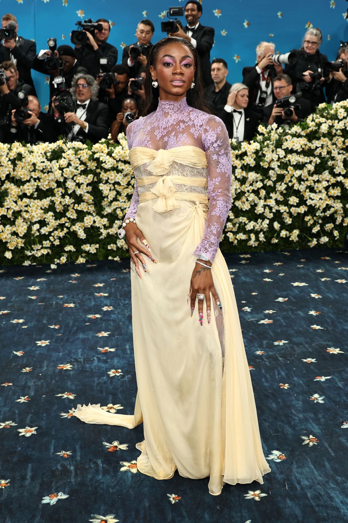 Sprinter Sha’Carri Richardson’s sunny yellow chiffon dress, by Valentino, was layered with a floral lace turtleneck bodice.