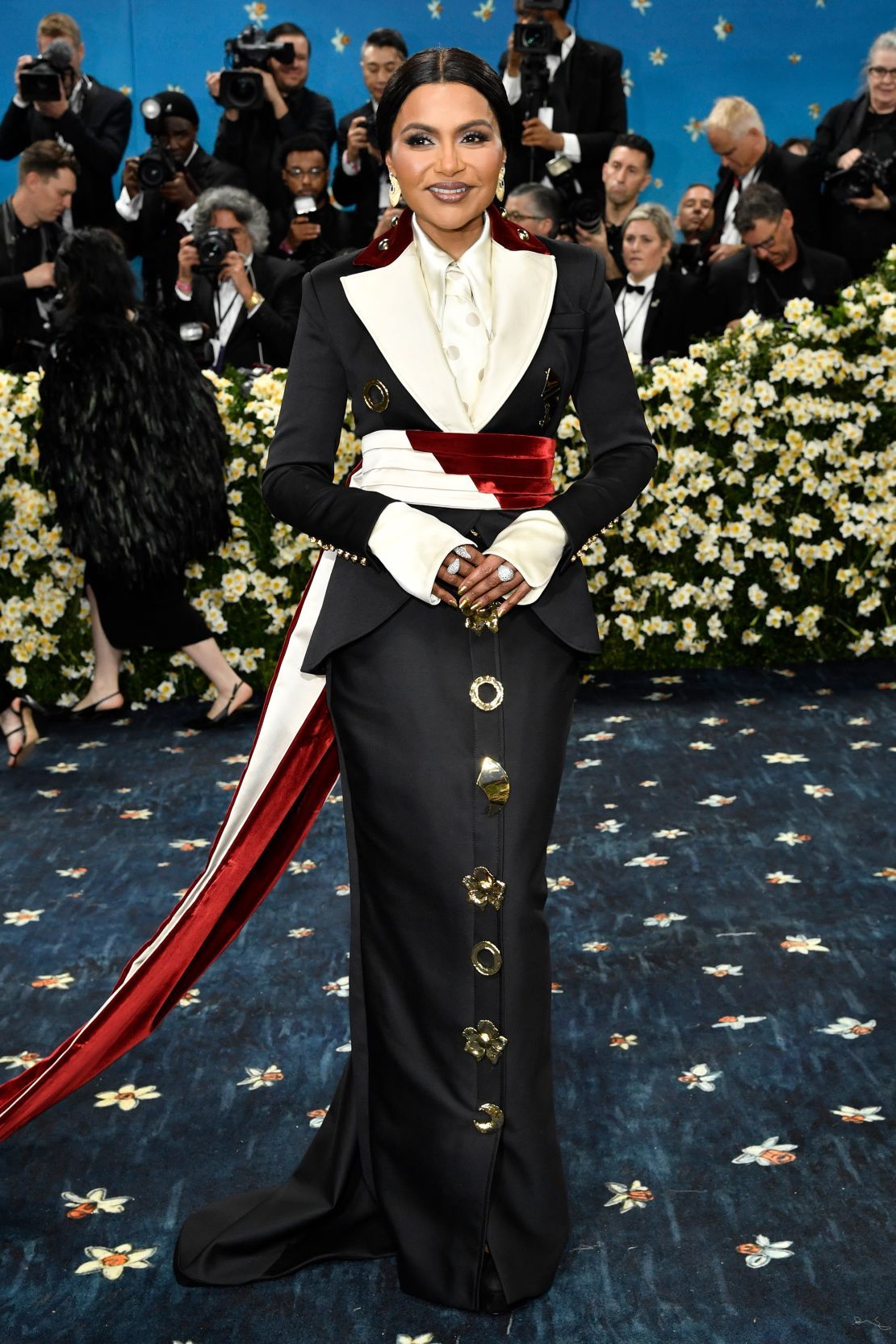 Mindy Kaling wore custom Harbison Studio, embellished with golden brooches and pops of red.