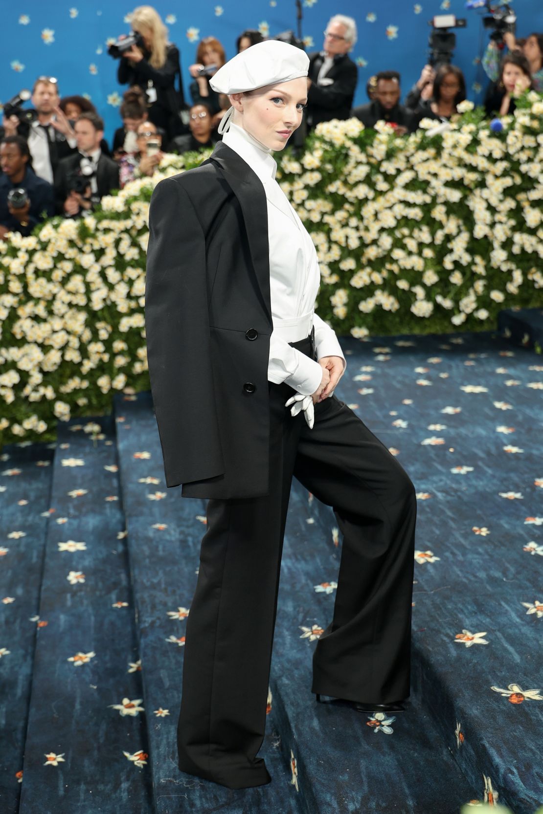 “Euphoria” actress Hunter Schafer arrived in a monochrome, multi-layered suit and flared pants, topped with a white beret.