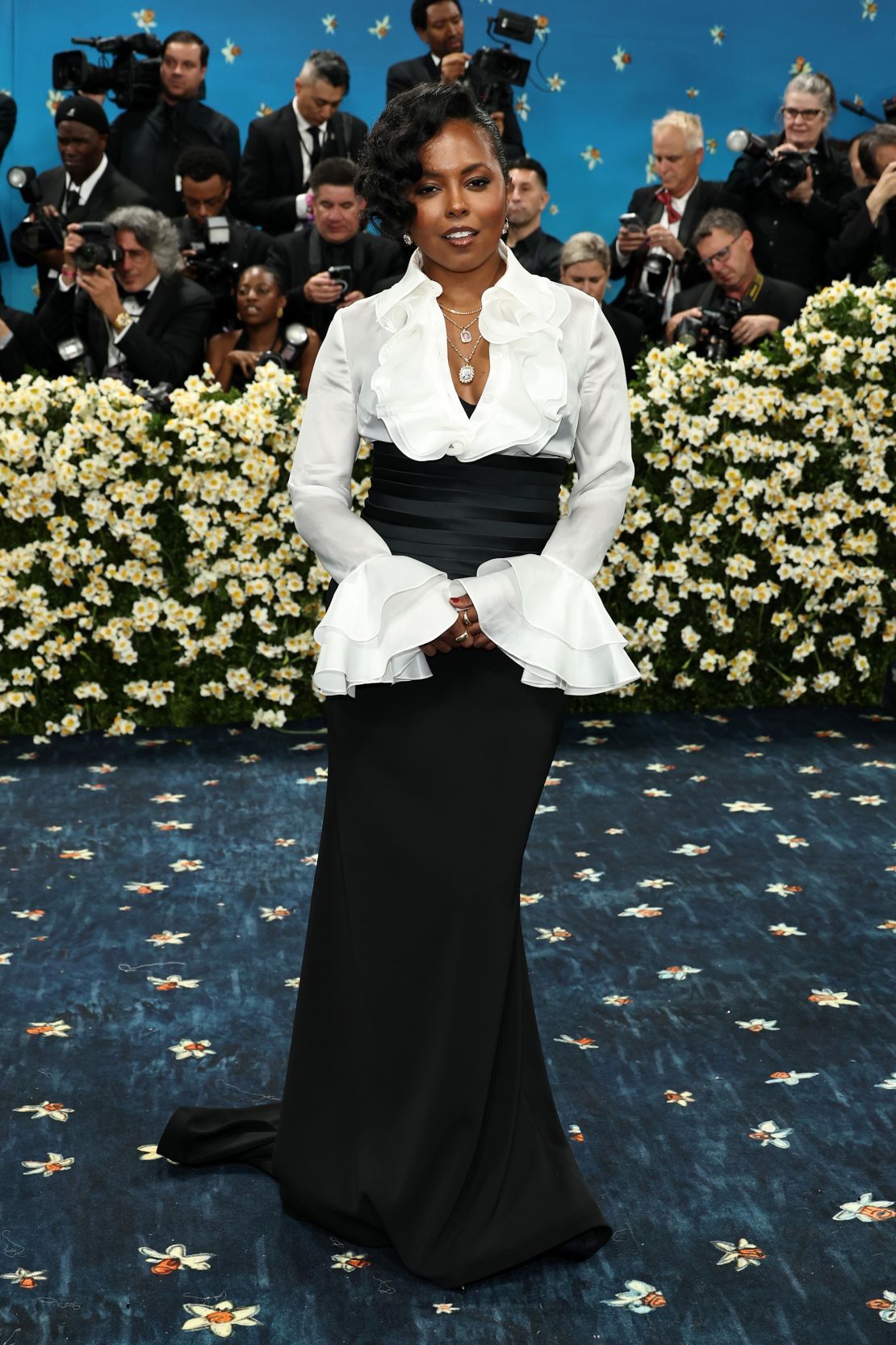 Tony Award-winning actor Adrienne Warren wore a white silk satin-faced organza ruffle blouse with a black corseted cummerbund evening skirt, all designed by Sergio Hudson.