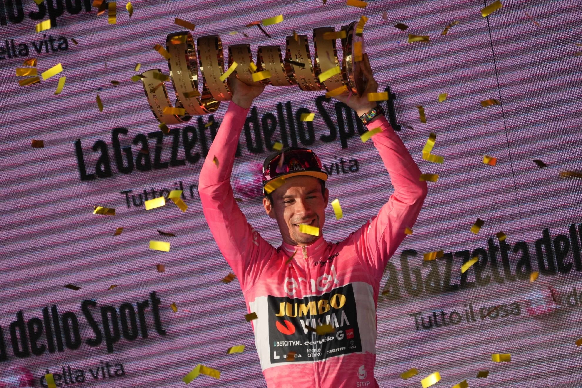 Primoz Roglic lifts the Senza Fine trophy after winning the Italian turn.