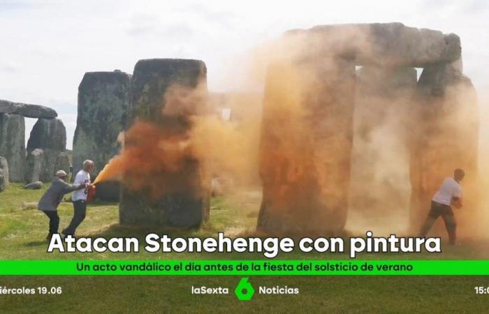 Two environmental activists spray orange paint on the Neolithic monument of Stonehenge (England)