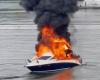 Massive boat fire breaks out aboard vessel as large plume of black smoke rises above the water